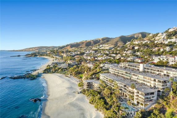 Wide angle view of coastal area with beachfront and hillside houses.