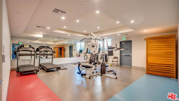 Indoor gym area with exercise equipment and mirrors.