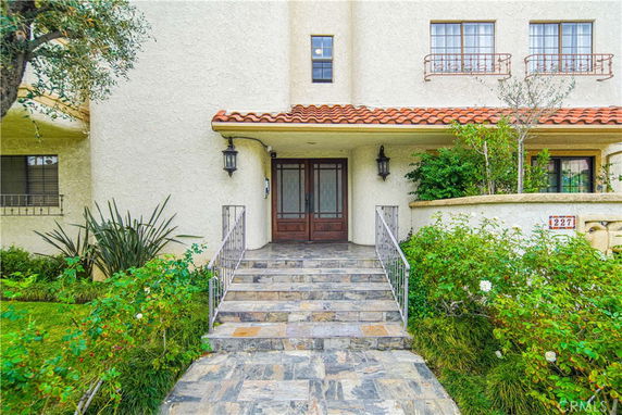 Front view of a building with a tiled roof and a stone walkway leading to the entrance.