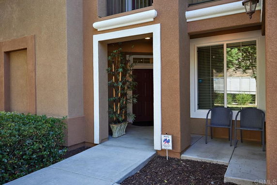 Front view of a house with an entrance walkway and window seating area.