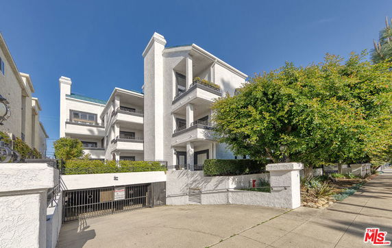 Front view of a multi-story apartment building with balconies.