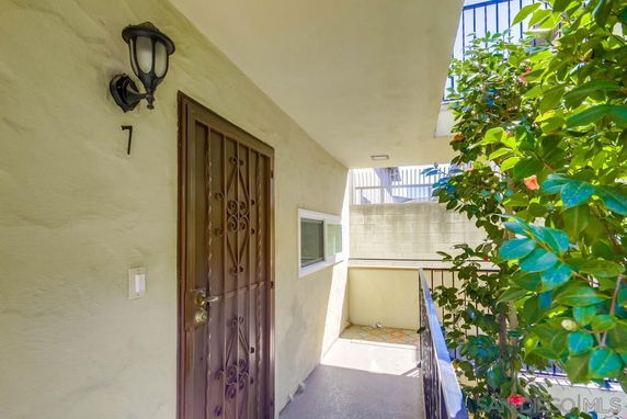 Entrance view of a building unit with a metal door and outdoor light.