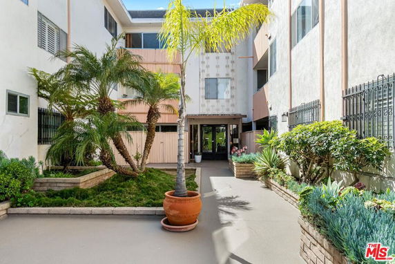 Front view of a multi-story building with a landscaped entrance