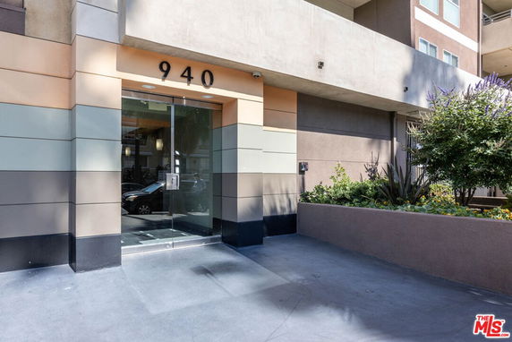 Front view of a modern building entrance with glass door and building number 940.