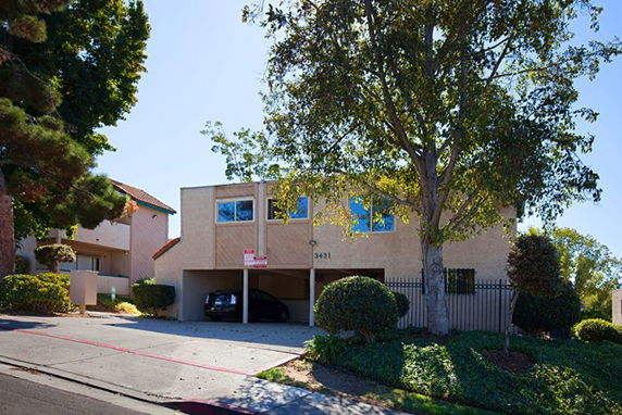 Front view of a two-story building with a covered parking area.
