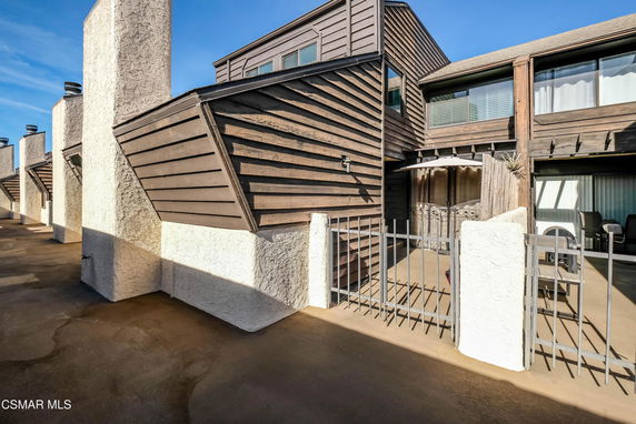 Front view of a multi-story residential building with wood and stucco exterior.
