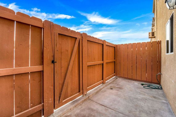 Outdoor space with wooden fencing and concrete ground.