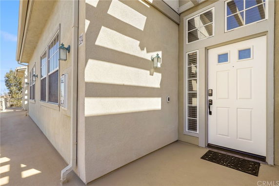 Front view of a house entryway with a white door and windows.
