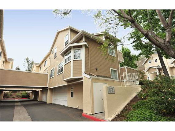 Front view of a multi-story house with a garage and walkway.