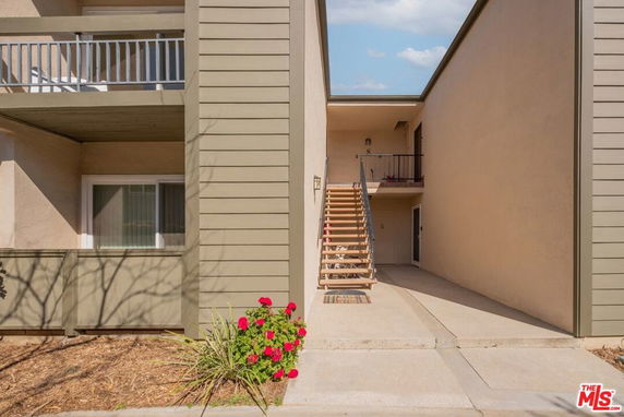Front view of a two-story apartment building with exterior stairs leading to the upper level.
