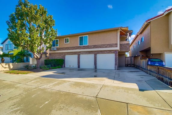 Front view of a two-story house with three garage doors.