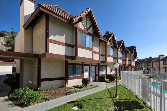 Front view of a row of two-story houses with a Tudor-style design.