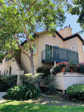 Front view of a two-story house with a balcony and chimney.