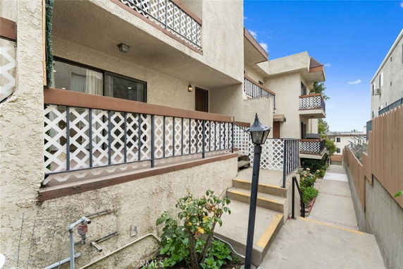 Front view of a multi-story apartment building with balconies and lattice railings.