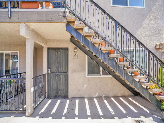 Front view of a building with exterior stairs and door.