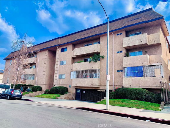 Front view of a multi-story apartment building with balconies.