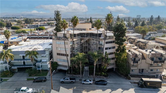 Front view of a multi-story residential building surrounded by other buildings.