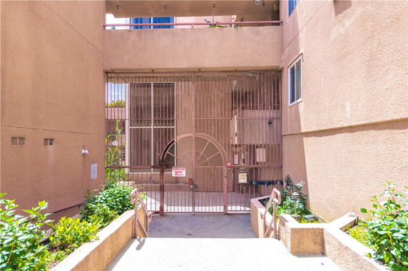 Front view of a gated entrance to a building with beige walls.