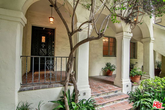 Front view of a house with a covered entryway and arched columns.