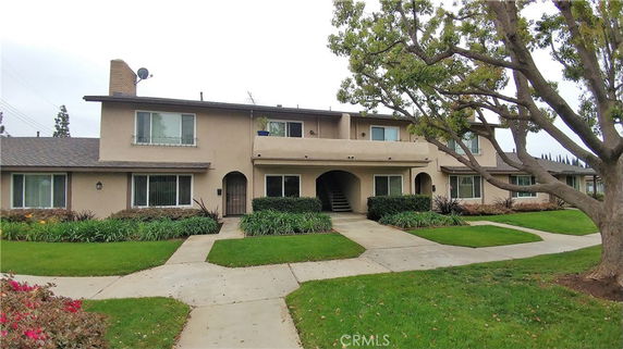 Front view of a two-story residential building with multiple entrances and windows.