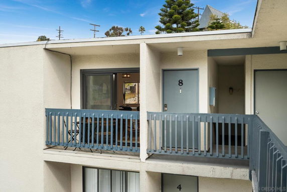 Exterior view of an upper-level apartment with a balcony.