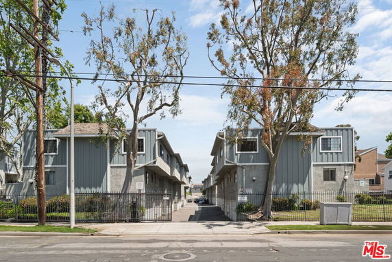 Front view of a residential building with grey and blue siding and a sloped roof.