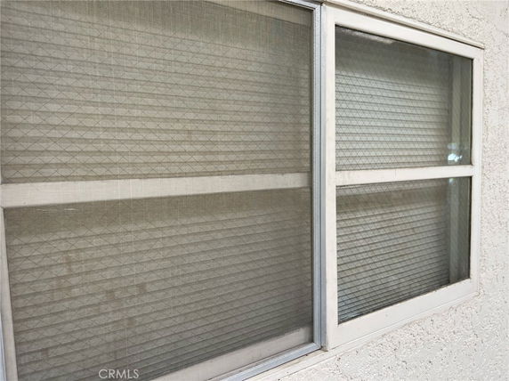 Close-up view of a window on a stucco building exterior.