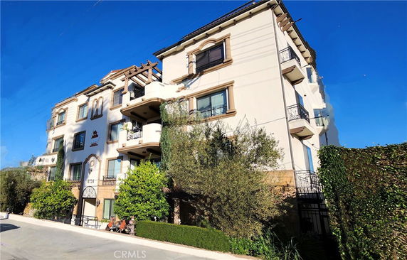 Front view of a multi-story building with balconies and a decorative facade.