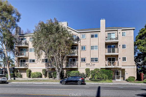 Front view of a multi-story apartment building with balconies.