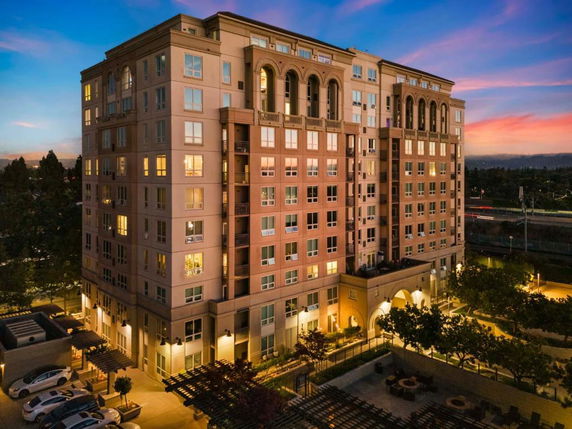 Front view of a multi-story building with a symmetrical facade and large windows.