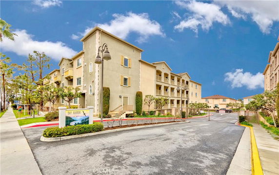 Front view of a multi-story apartment building with a gated entrance.