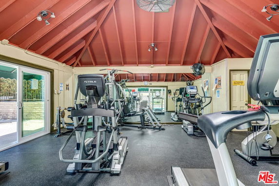Indoor fitness area with exercise equipment and a high ceiling.