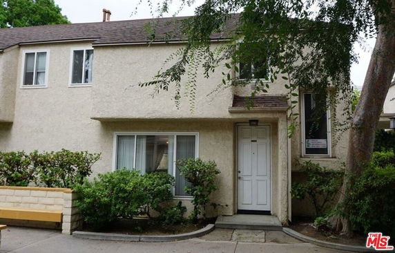 Front view of a two-story house with a central entrance and multiple windows.
