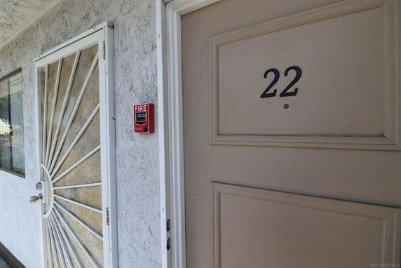 Close-up view of the front door labeled 22 and a security screen door.