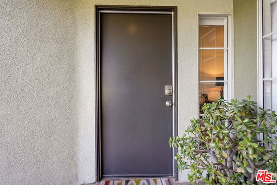 Front view of a house entrance with a black door and a small window.