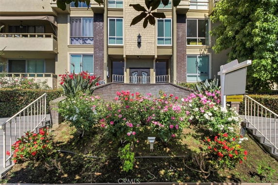 Front view of a multi-story building with a landscaped garden.