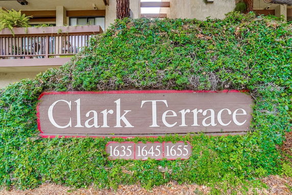Front view of a building with a sign reading 'Clark Terrace' covered in greenery.