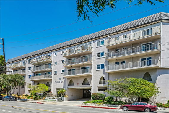 Front view of a multi-story apartment building with balconies on each floor.