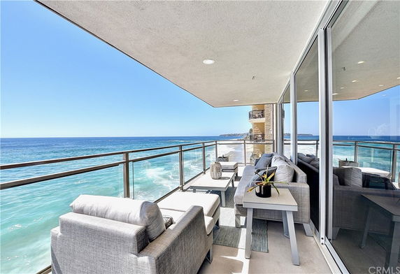 Outdoor balcony with ocean view and seating area.