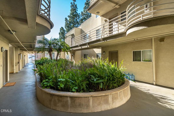 View of a multi-level building exterior with balconies and central planter.