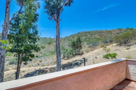 View of hills and trees from a building's balcony.