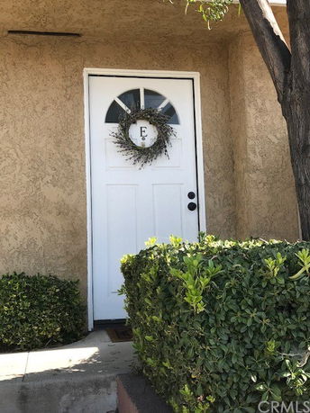 Front view of a house with a white door featuring a wreath.