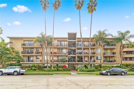 Front view of a multi-story apartment building with balconies.