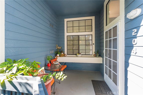 Entrance view of a house with blue siding and a window with white trim.