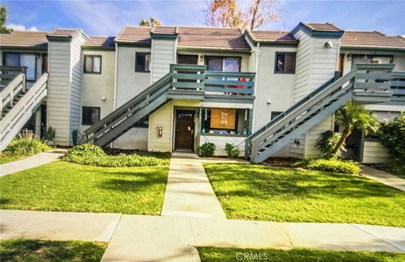 Front view of a multi-story apartment building with exterior staircases.