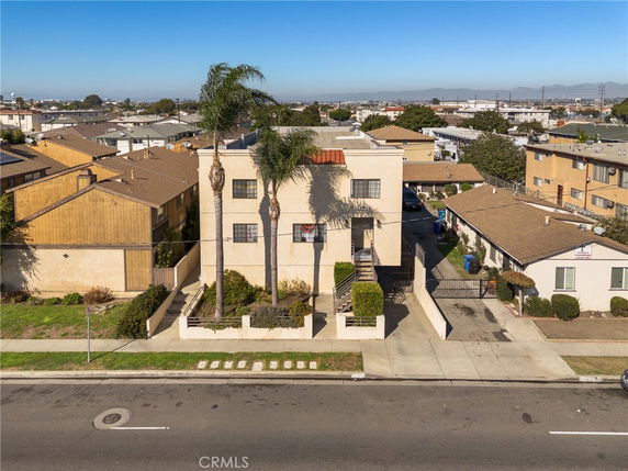 Front view of a multi-story building with palm trees in front.