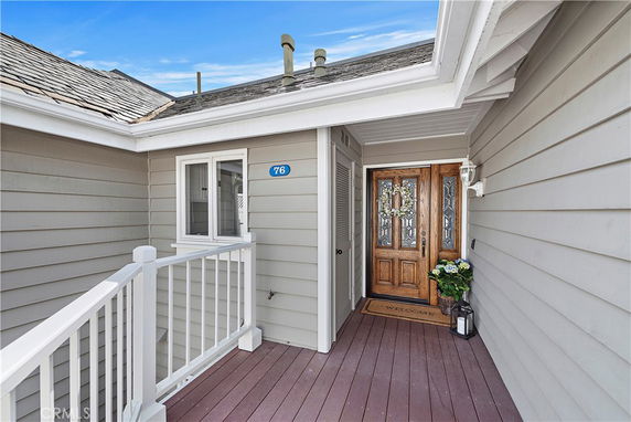 Front view of a house entrance with wooden door and a small porch.