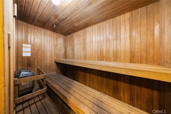 Interior view of a wooden sauna room with benches and a heater.