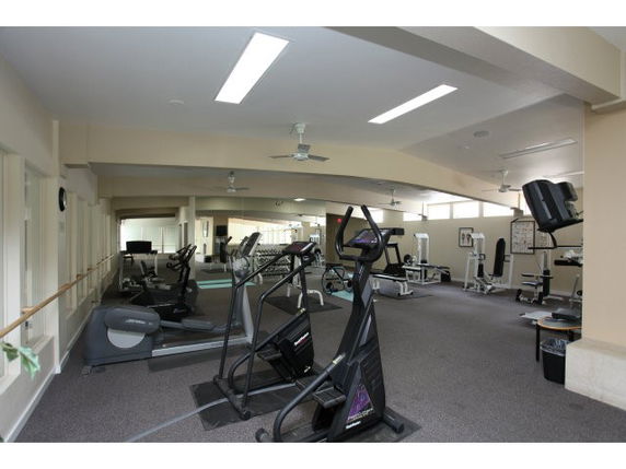 Indoor gym area with various exercise equipment including treadmills and ellipticals.