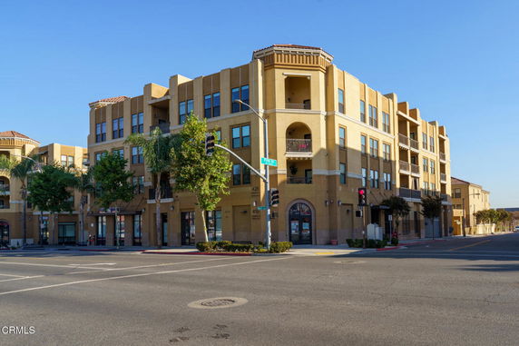 Front view of a multi-story apartment building on a street corner.